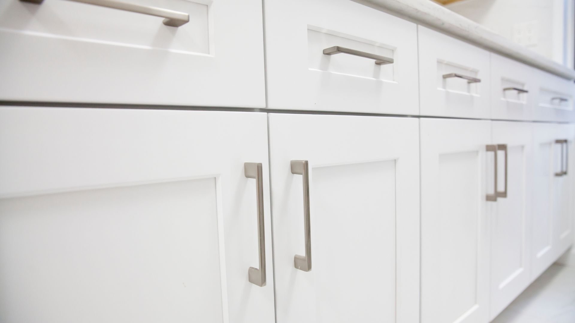 White kitchen cabinets with modern metal handles