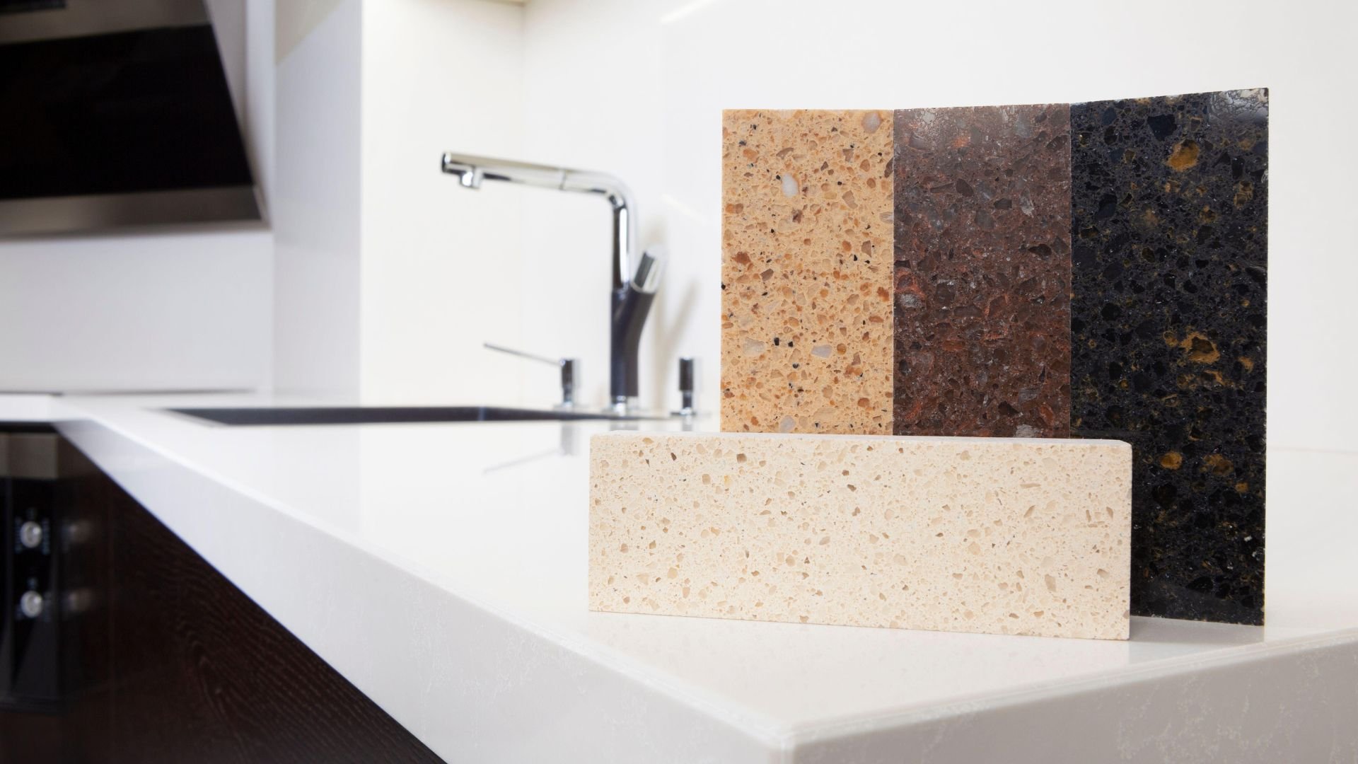Quartz countertop samples in different colors displayed near kitchen sink