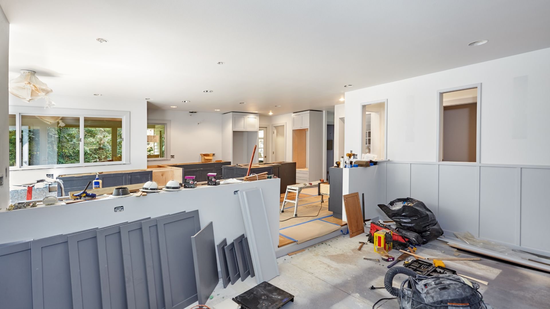Kitchen renovation in progress with construction materials and tools scattered around