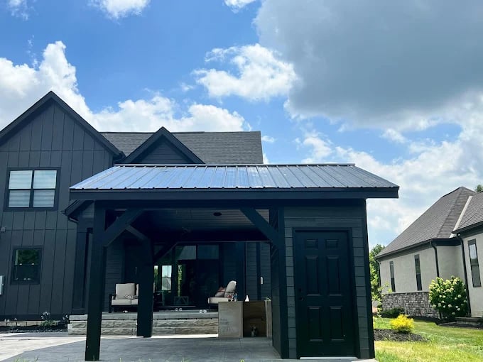 Black outdoor pavilion with metal roof and seating area on sunny day