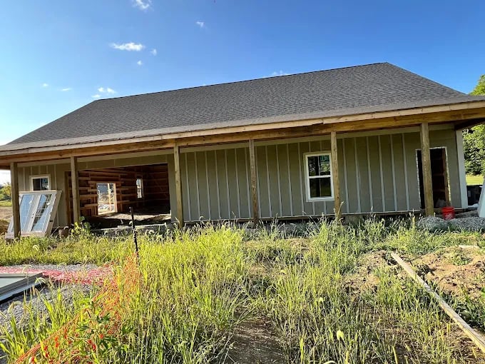 Rustic wooden cabin with log and board siding under blue sky