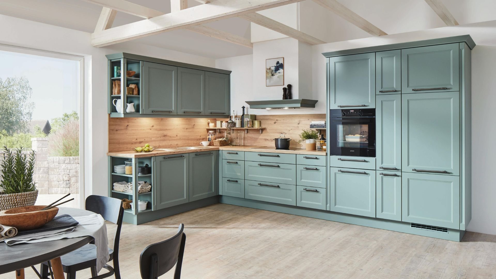 Modern mint green kitchen with wooden countertops and built-in appliances