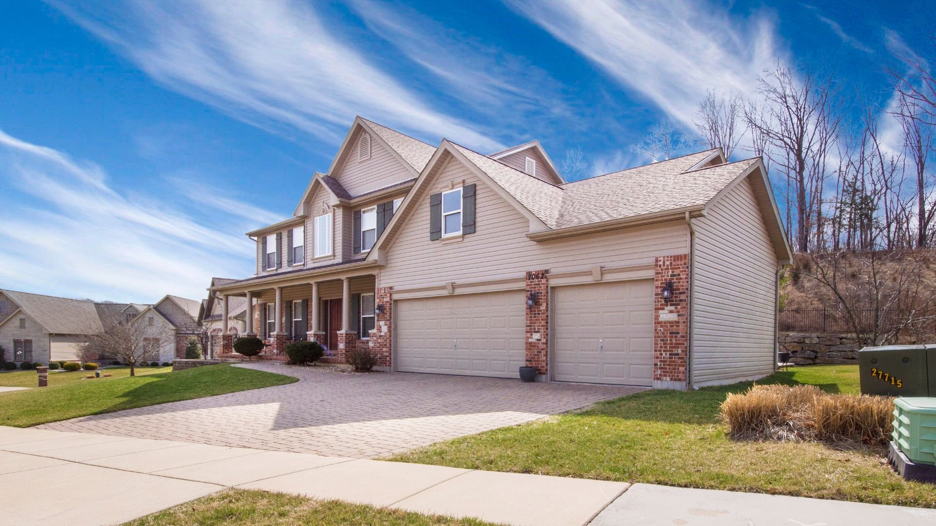 Two-story suburban house with brick accents and three-car garage
