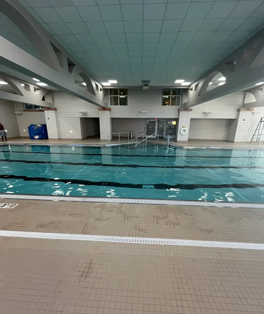 Indoor swimming pool with blue water and tiled walls and floor