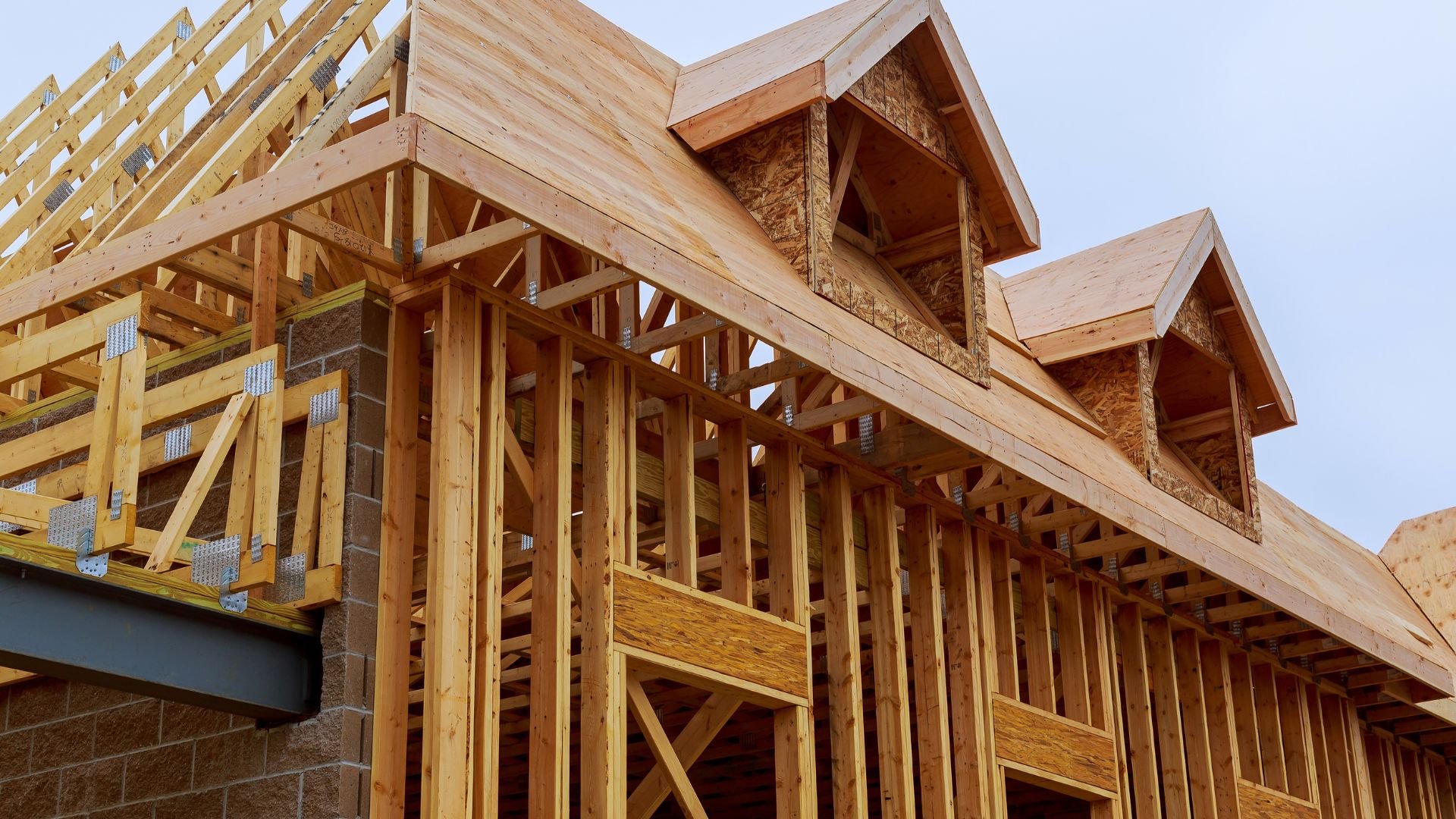 Wooden house framing with roof trusses and dormer windows under construction
