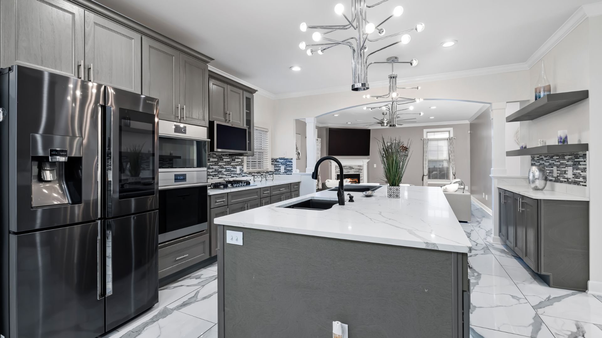 Modern grey and white kitchen with marble countertops and stainless steel appliances